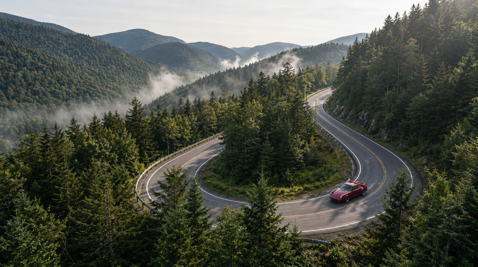 A red 911 rounding a forested Green Mountain hairpin at golden hour